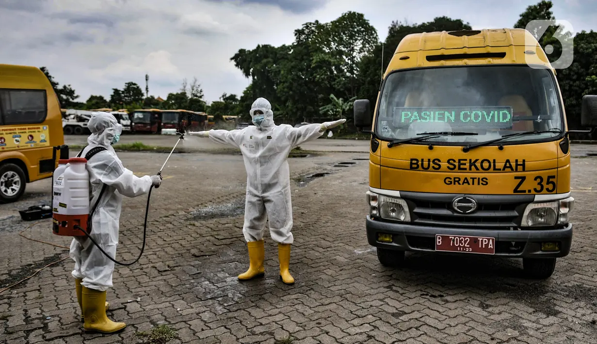 Petugas Kebersihan Bus (PKB) menyemprotkan disinfektan pada sopir bus sekolah saat proses dekontaminasi usai bertugas mengantarkan pasien terpapar Covid-19 di Pool Unit Pelayanan Angkutan Sekolah (UPAS) DKI Jakarta, Kramat Jati, Selasa (5/1/2021). (merdeka.com/Iqbal Nugroho)