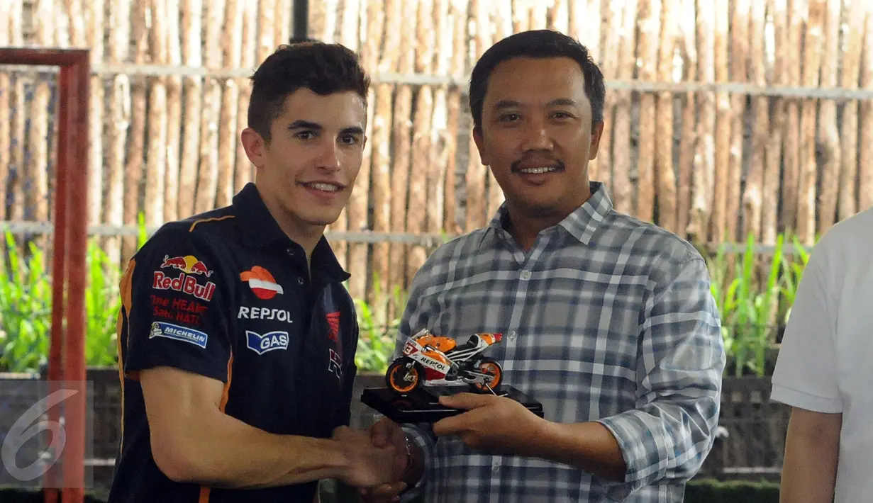Marc Marquez (kiri) memberikan cenderamata kepada Menpora Imam Nahrawi di Jakarta, Sabtu (13/2/2016). Marc Marquez bersama Dani Pedrosa akan diperkenalkan sebagai tim Repsol Honda MotoGP 2016 di Sirkuit Sentul. (Liputan6.com/Helmi Fithriansyah)