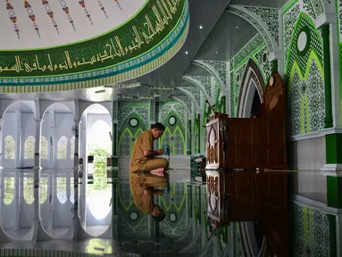 Seorang pria berdoa usai menunaikan salat selama bulan Ramadan di masjid Al Munawarah di Jantho, provinsi Aceh (12/5/2020). Masjid Al Munawarah yang berdiri di pusat Kota Jantho, Kabupaten Aceh Besar dikelilingi oleh perbukitan Bukit Barisan. (AFP/Chaideer Mahyuddin)