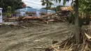 Sebuah alat berat berusaha mengevakuasi puing-puing dan batang pohon yang tumbang asca banjir bandang di Kabupaten Sentani, Jayapura, (17/3). Banjir bandang Sentani menewaskan 70 orang dan puluhan luka-luka. (AFP/Netty Dharma Somba)