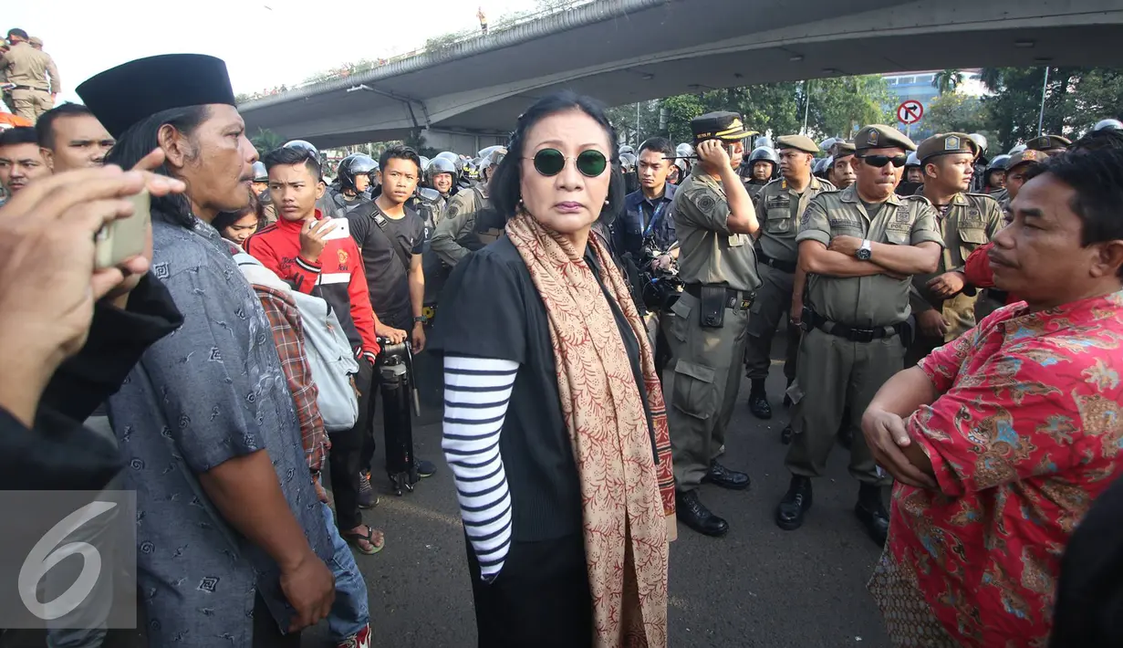Ratna Sarumpaet menggunakan kaca mata hitam saat penertiban pemukiman penduduk di kawasan Rawajati, Jakarta, Kamis (1/9). Keberadaan Ratna di lokasi tersebut guna membantu mediasi warga yang rumahnya dieksekusi petugas. (Liputan6.com/Immanuel Antonius)