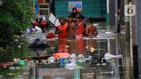 Sejumlah anak bermain banjir yang merendam kawasan Kampung Melayu Kecil, Bukit Duri, Jakarta, Selasa (25/2/2020). Banjir tersebut akibat luapan sungai Ciliwung. (merdeka.com/magang/ Muhammad Fayyadh)