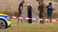 Polisi dan Polisi Militer mengamankan bagian dari sebuah objek yang ditembak jatuh otoritas Polandia di Wohyn, Rabu, 10 September 2025. Gambar ini diambil dari rekaman video. (Dok. AP Photo/Rafal Niedzielski)