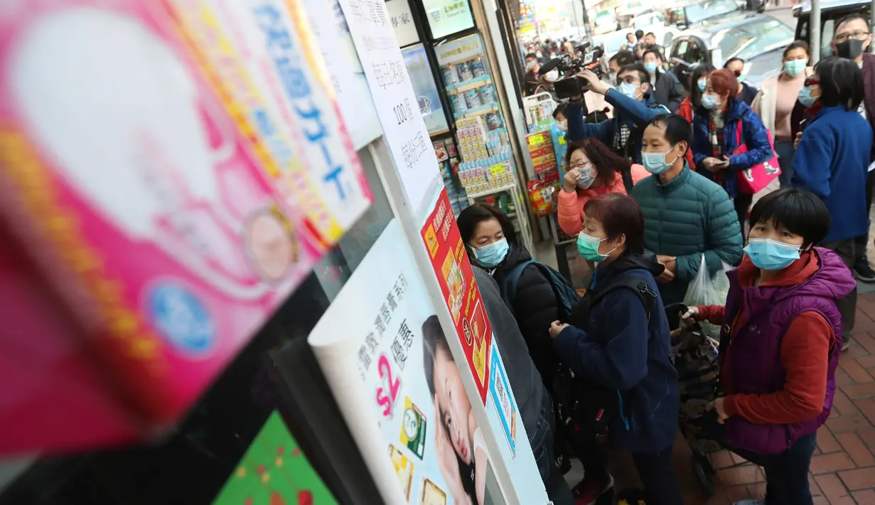 Warga mengantre untuk mendapatkan masker wajah gratis di luar sebuah toko di Tsuen Wan, Hong Kong, Selasa (28/1/2020). Hong Kong terkonfirmasi memiliki delapan kasus infeksi virus corona. (AP Photo/Achmad Ibrahim)