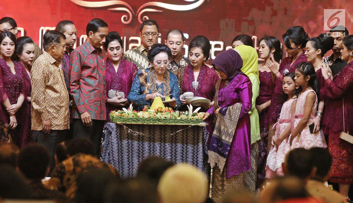 Pendiri PT Mustika Ratu Tbk, Mooryati Soedibyo (tengah) memotong tumpeng saat perayaan ulang tahunnya yang ke 90 di kawasan Gatot Subroto, Jakarta, Jumat (5/1). (Liputan6.com/Herman Zakharia)