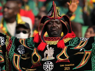 Seorang Suporter Kamerun menari sebelum dimulainya pertandingan sepak bola grup A Piala Afrika 2021 antara Kamerun melawan Burkina Faso di stadion Olembe di Yaounde, Minggu, (9/1/2022). Piala Afrika 2021 seharusnya digelar Januari 2021 tapi kemudian diundur karena pandemi. (AP Photo/Themba Hadebe)