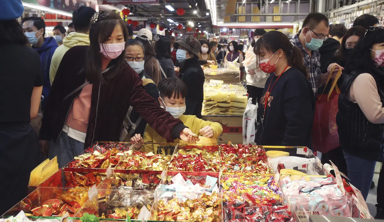 Warga mengenakan masker untuk mencegah penyebaran virus corona berbelanja untuk perayaan Tahun Baru Imlek di pasar Dihua Street di Taipei, Taiwan, Rabu (10/2/2021).  Warga Taiwan mulai berburu makanan lezat, barang kering, dan pernak-pernik lainnya untuk merayakan Imlek. (AP Photo/Chiang Ying-ying)