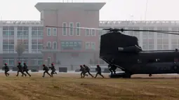 Tentara yang turun dari helikopter Chinook berlari saat latihan peningkatan kesiapsiagaan yang mensimulasikan pertahanan terhadap gangguan militer China jelang Tahun Baru Imlek di Kota Kaohsiung, Taiwan, 11 Januari 2023. China memperbarui ancamannya untuk menyerang Taiwan dan memperingatkan bahwa negara tersebut telah "bermain api". (AP Photo/Daniel Ceng)