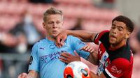 Bek Manchester City, Oleksandr Zinchenko berebut bola dengan pemain Southampton Che Adams dalam lanjutan Liga Inggris di St. Mary Stadium, Minggu (5/7/2020).  Manchester City gagal memetik poin penuh setelah kalah tipis 0-1 saat bertandang ke markas Southamtpon. (AP Photo/Frank Augstein, Pool)