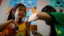 Seorang siswi meringis saat disuntikkan vaksin anti-dengue di Sekolah Dasar Parang di Marikina, sebelah barat Manila, Senin (4/4). Filipina telah menyuntikkan vaksin pertama di dunia untuk penyakit DBD itu kepada 1 juta pelajar. (NOEL CELIS/AFP)