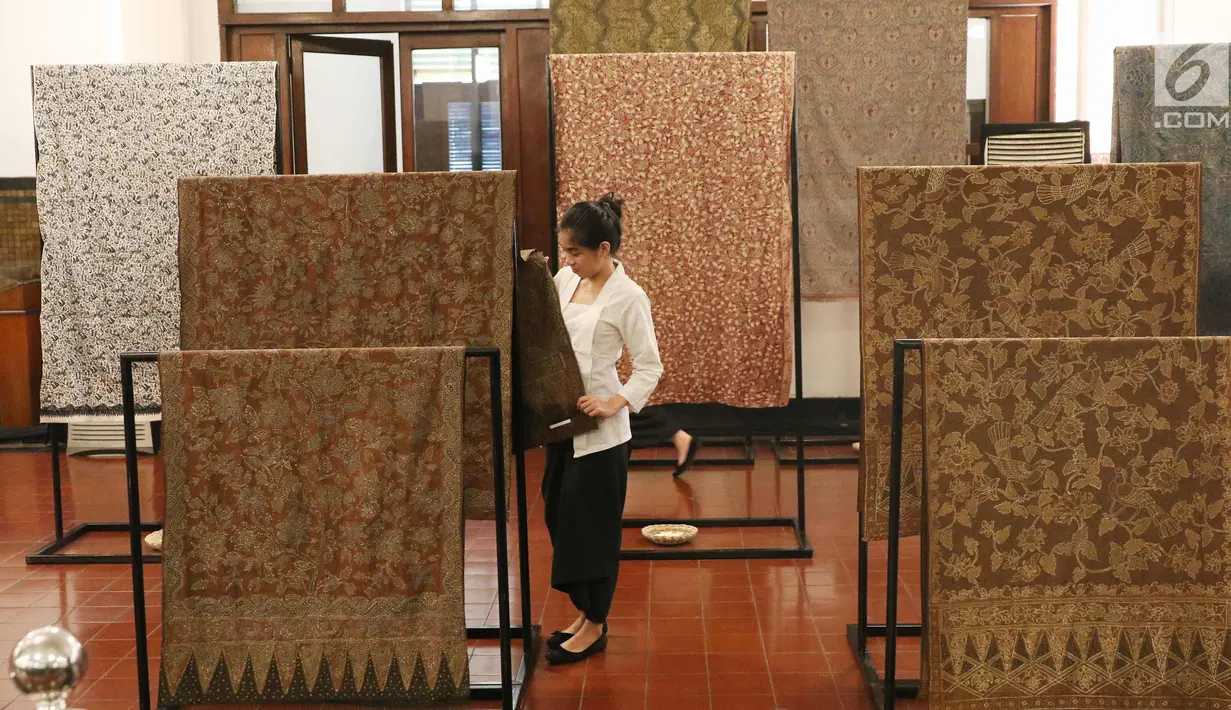 Seorang pengunjung melihat kain batik di Musium Bank Mandiri, Jakarta, Rabu (25/10). Pameran batik 100 kain negeri tersebut merupakan karya desainer Oscar Lawalata. (Liputan6.com/Angga Yuniar)