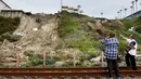 Kru dengan Otoritas Kebakaran Orange County menanggapi tempat kejadian di blok 1500 Buena Vista setelah menerima panggilan 911 tentang tanah longsor tak lama setelah pukul 08:00. (MARIO TAMA / GETTY IMAGES NORTH AMERICA / GETTY IMAGES VIA AFP)