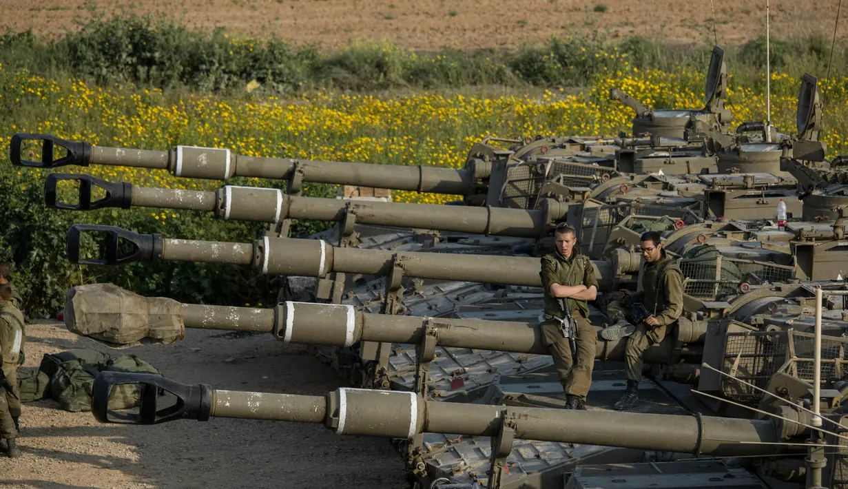 Tentara Israel duduk di atas artileri dekat perbatasan dengan Gaza, Rabu (27/3). Mobilisasi tentara Israel ke perbatasan Gaza dilakukan ketika suasana telah mereda setelah baku tembak dengan kelompok Hamas. (AP Photo/Tsafrir Abayov)
