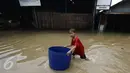 Seorang anak berada di tengah banjir di jalan Merpati Raya kota,Tangerang Selatan, Selasa (21/2). Intensitas curah hujan yang tinggi di sertai buruknya Drainase menyebabkan banjir 50-100 cm di kawasan tersebut. (Liputan6.com/Helmi Afandi)
