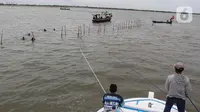 Selanjutnya, perahu melaju untuk menarik bambu itu hingga copot. (Magang/Liputan6.com/Muhammad Rizal)