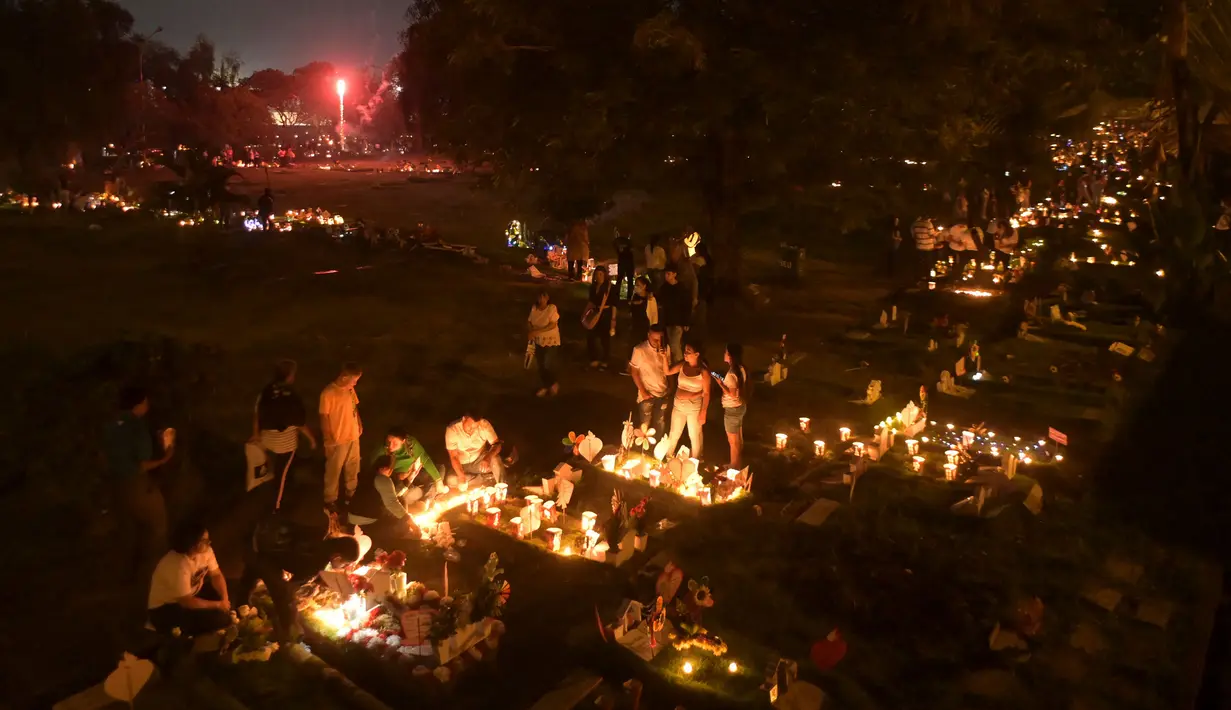 Hari Lilin Kecil ('Dia de las velitas') juga dirayakan di sebuah pemakaman, Cali, Kolombia, pada 7 Desember 2023. (JOAQUIN SARMIENTO/AFP)