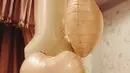 Balon angka satu berukuran besar dipadukan dengan balon hati menjadi focal point, sementara boneka kelinci, buket bunga peony berwarna pink, serta kain rajut pastel membuat suasana terasa hangat dan dreamy. [@alyssadaguise].