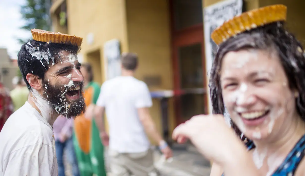 Peserta tertawa ketika kue pai mendarat di atas kepalanya dalam acara "pie fight" di Berlin, Jerman, 19 Juni 2015. Acara ini diselenggarakan oleh sebuah bioskop di Jerman. (REUTERS/Hannibal Hanschke)