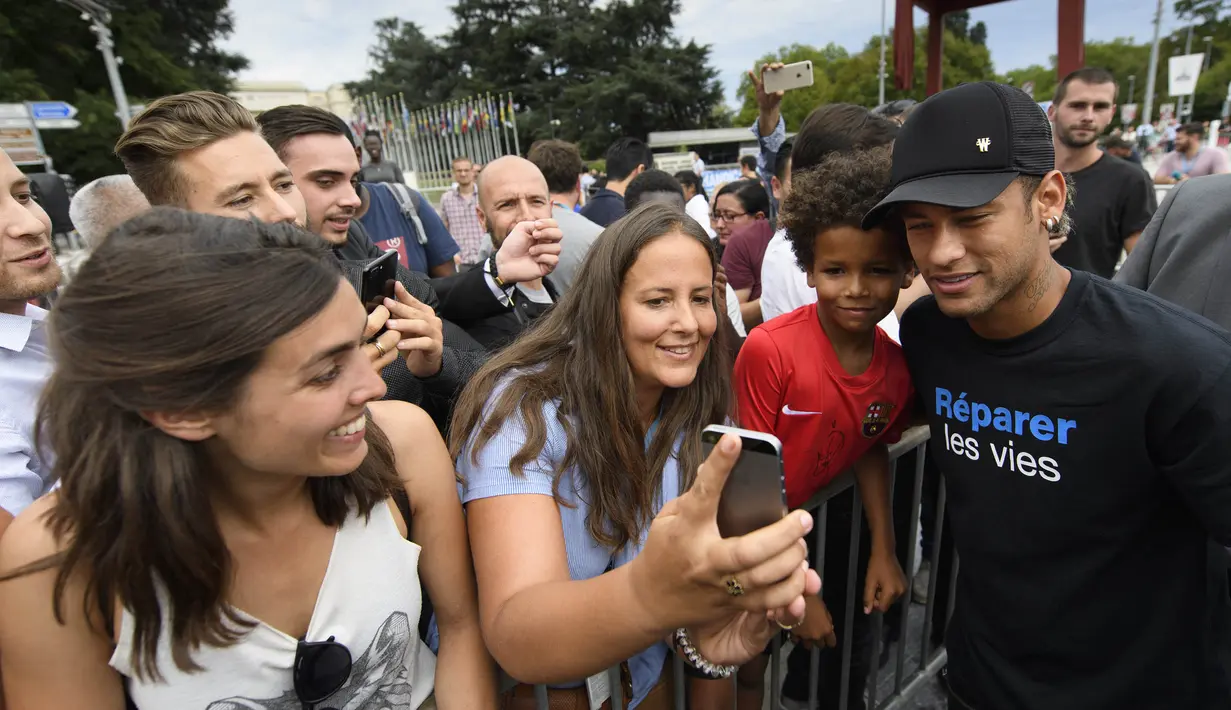 Bintang Paris Saint-Germain, Neymar Jr, foto bersama penggemarnya usai menghadiri konferensi pers di Kantor PBB, Jenewa, (15/8/2017). Neymar Jr akan fokus membantu orang-orang cacat dan terpuruk dalam kemiskinan. (AP/Laurent Gillieron)