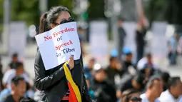 Seorang pengunjuk rasa membawa sebuah kertas bertuliskan "Tidak ada kebebasan bicara di Tibet" Jenewa, Jumat (16/9). Pengunjuk rasa meminta Presiden Tiongkok, Xi Jinping untuk menghentikan pembunuhan di Tibet. (AFP PHOTO/Fabrice Coffrini)