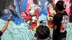 Peserta menyelesaikan pembuatan mural saat mengikuti pelatihan seni mural di Pusat Pelatihan Seni Budaya (PPSB) Jalan H Naman, Pondok Kelapa, Jakarta Timur, Selasa (24/6/2025). (Liputan6.com/Herman Zakharia)