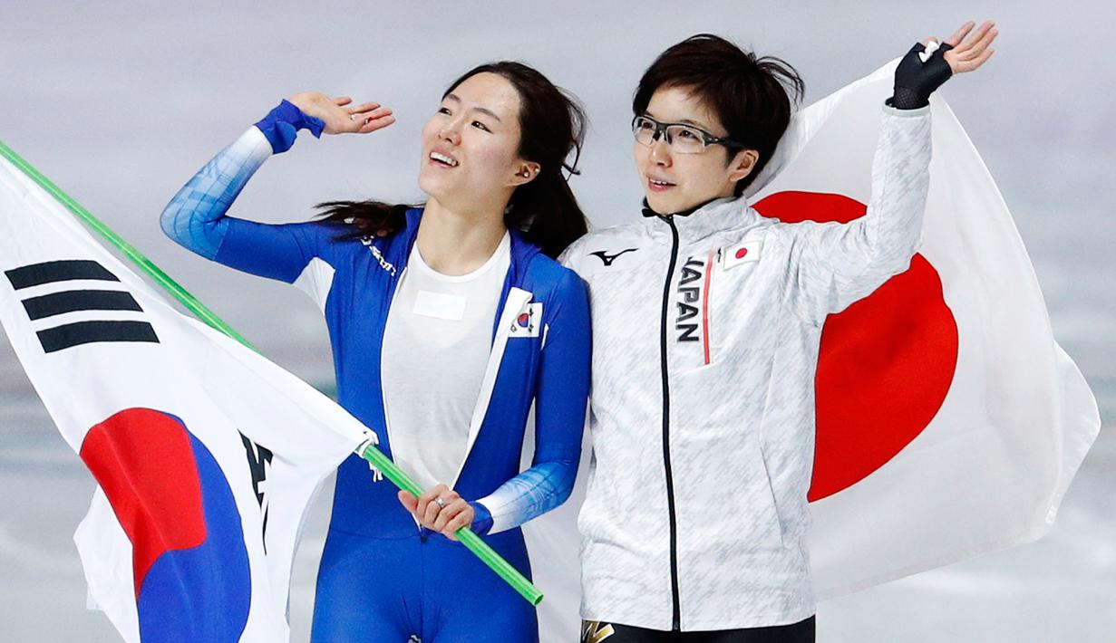 Peraih medali emas, skater Nao Kodaira dari Jepang dan peraih perak, skater Lee Sang Hwa dari Korea Selatan merayakan kemenangan mereka pada cabang skating speed 500 meter putri di Olimpiade Musim Dingin Pyeongchang 2018, Minggu (18/2). (AP/John Locher)