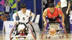 Pebasket Indonesia, Kasep Ayatulloh, berebut bola dengan pebasket Thailand, Roongrote Chaiman, pada Asian Para Games di Hall Basket, Jakarta, Rabu (10/10/2018). Indonesia kalah 10-62 dari Thailand. (Bola.com/M Iqbal Ichsan)