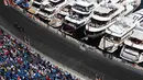 Pebalap McLaren, Jenson Button, melintas di depan deretan kapal pribadi dan tribun penonton pada latihan bebas F1 GP Monako, (26/5/2016). (AFP/Valery Hache)
