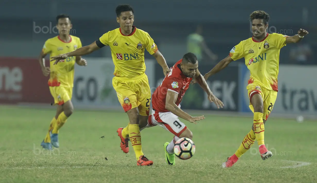 Striker Persija, Luis Junior, dijatuhkan bek Bhayangkara FC, Indra Kahfi, pada laga Liga 1 di Stadion Patriot Bekasi, Jawa Barat, Sabtu (29/7/2017). Persija menang 1-0 atas Bhayangkara FC. (Bola.com/M Iqbal Ichsan)