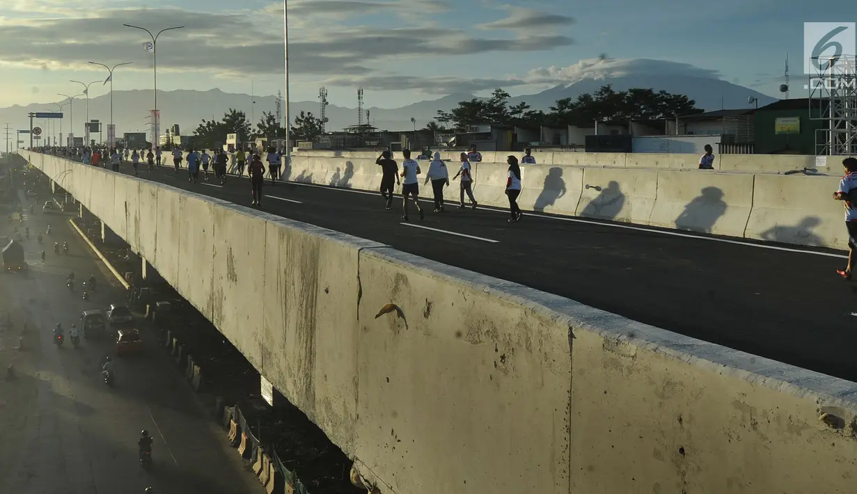 Pemandangan saat Tol Bogor Outer Ring Road (BORR) dipenuhi peserta lari Bogor Running Race dengan latar belakang pegunungan, Bogor (01/04). Lomba lari ini dilakukan dalam rangka jelang peresmian Jalan Tol BORR Seksi IIB. (Merdeka.com/Arie Basuki)