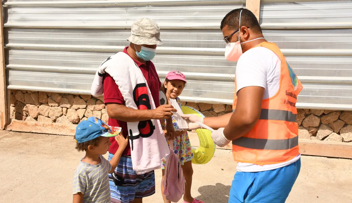 Petugas kesehatan membagikan masker kepada seorang pria di sebuah pantai di Rabat, Maroko, 27 Agustus 2020. Maroko pada 27 Agustus 2020 melaporkan 1.221 kasus baru COVID-19, menambah jumlah kasus infeksi di negara itu sejak 2 Maret menjadi 57.085. (Xinhua/Chadi)