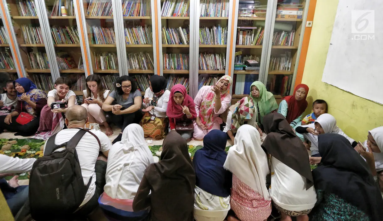 Sejumlah anak yatim, kaum dhuafa serta lima WNA menikmati makanan nasi liwet sambil lesehan di Rumah Amalia, Ciledug, Kota Tangerang, Sabtu (3/3). Komunitas couchsurfing Indonesia bertujuan membuka jendela pengetahuan anak-anak (Liputan6.com/Fery Pradolo)