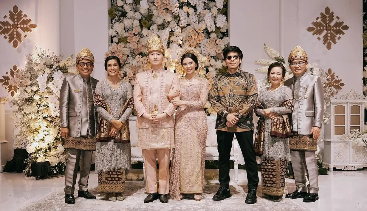 Sama halnya dengan Rachell, Glory juga mengenakan tampilan beskap berbeda untuk momen resepsi. Beskap cokelat dengan sentuhan warna rose gold pada kain wastra yang dikenakannya membuat penampilan Glory terlihat berbeda dan menonjol. [Foto: Instagram/attahalilintar]