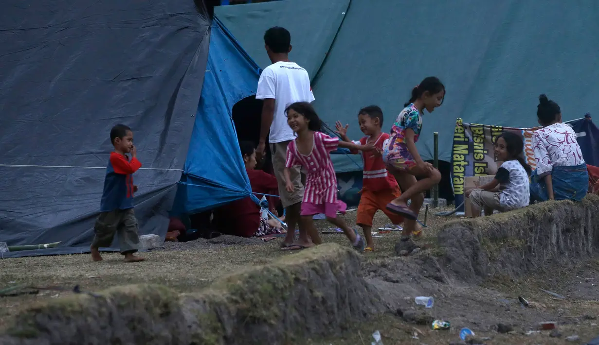 Anak-anak bermain di tempat penampungan pengungsi korban gempa bumi di Lombok Utara,  NTB, Rabu (8/8). BPBD Lombok Utara mencatat data sementara jumlah korban jiwa akibat gempa Lombok mencapai 347 orang. (AP/Tatan Syuflana)