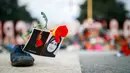 Sepatu bertabur bunga dengan sebuah gambar mewarnai unjuk rasa menentang pidato Menteri Kehakiman Iran, Sayyid Alireza Avaei di hadapan dewan HAM Perserikatan Bangsa-Bangsa, di luar kantor PBB, Jenewa, Selasa (27/2). (Valentin Flauraud/Keystone via AP)