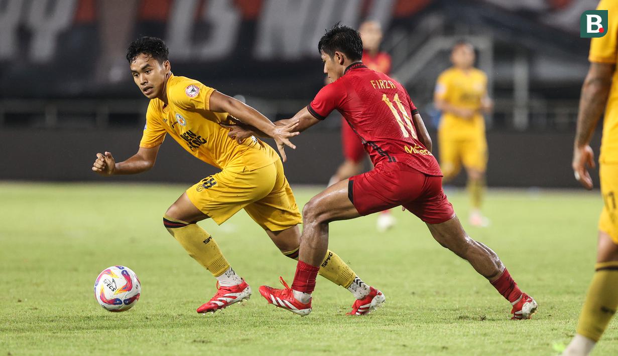 Pemain Semen Padang, Gala Pagamo mencoba melewati pemain Persija Jakarta, Firza Andika pada laga pekan ke-30 Liga 1 2024/2025 di Stadion Pakansari, Kabupaten Bogor, Minggu (27/4/2025). (Bola.com/Abdul Aziz)