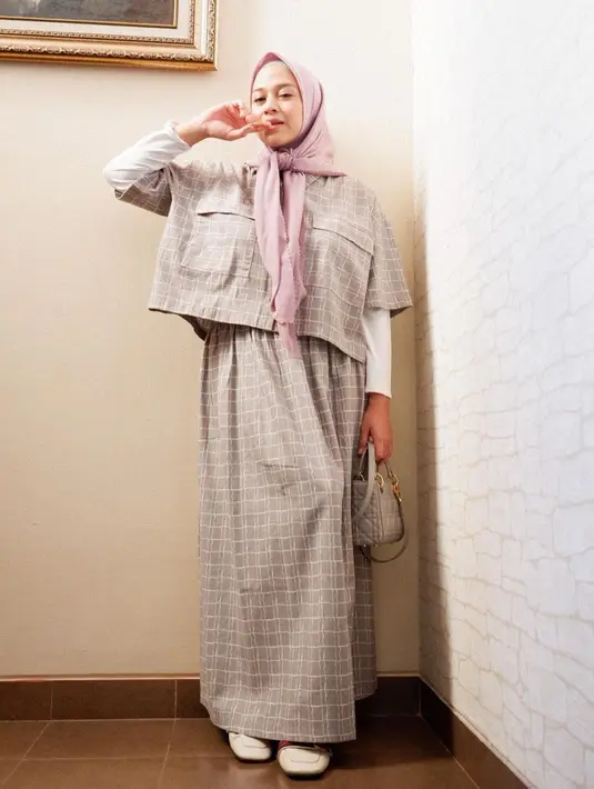 Gaya Nina Zatulini memadukan setelan baju dan rok bermotif kotak-kotak ini, dipadukan dengan inner putih, dan hijab warna pink bisa jadi inspirasi gaya kasual yang chic. (Instagram/ninazatulini22).
