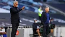 Pelatih Tottenham Hotspur, Jose Mourinho, dan pelatih Everton, Carlo Ancelotti, pada laga Premier League, Senin (6/7/2020). Mourinho rela langgar aturan jarak sosial demi memeluk Carlo Ancelotti. (AFP/Richard Heathcote)