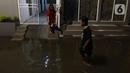 Warga sedang berjalan di tengah banjir yang melanda Jalan Bangka, Jakarta, Rabu (4/1/2023). Hujan deras yang terjadi pada Rabu sore membuat Kali Mampang meluap hingga menyebabkan banjir di kawasan tersebut dengan ketinggian bervariasi mulai dari 40 hingga 60 cm. (Liputan6.com/Herman Zakharia)