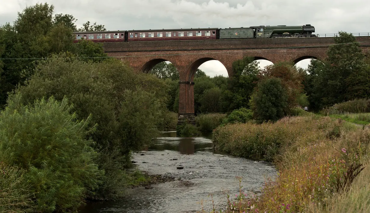 Lokomotif uap Flying Scotsman berjalan di sepanjang jalur East Lancashire Railway di Roch Valley Viaduct, Inggris, 5 September 2018. Flying Scotsman merupakan sebuah lokomotif uap yang diproduksi tahun 1923 di Doncester, South Yorkshire. (OLI SCARFF/AFP)