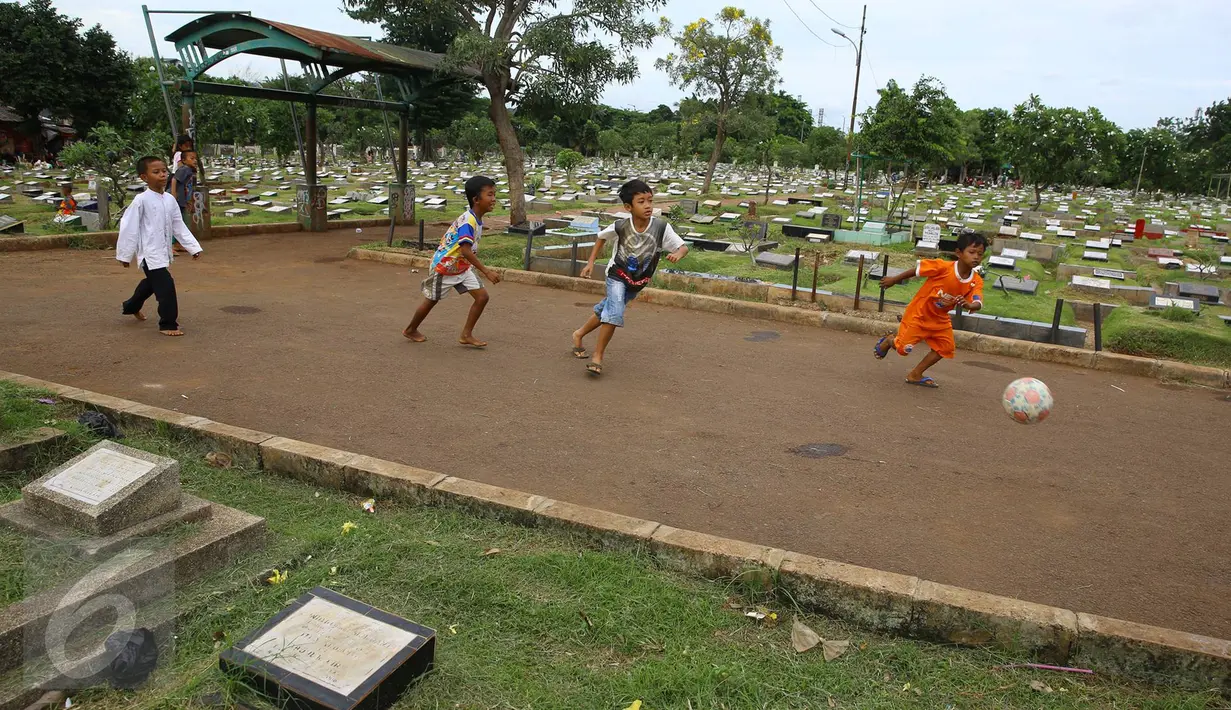 Anak-anak bermain bola di sekitar TPU Karet Bivak, Jakarta, Jumat (13/1). Semakin berkurangnya lahan hijau menyebabkan anak-anak di Ibukota terpaksa bermain di tempat yang tidak semestinya. (Liputan6.com/Immanuel Antonius)