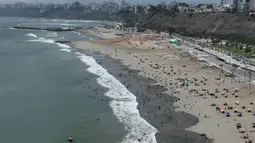 Pengunjung pantai menghabiskan waktu di pantai Agua Dulce di Lima, Peru, Kamis (30/12/2021). Pemerintah Peru mengumumkan penutupan pantai untuk 31 Desember - 1 Januari sebagai langkah untuk membantu mencegah penyebaran virus corona. (AP Photo/Guadalupe Pardo)