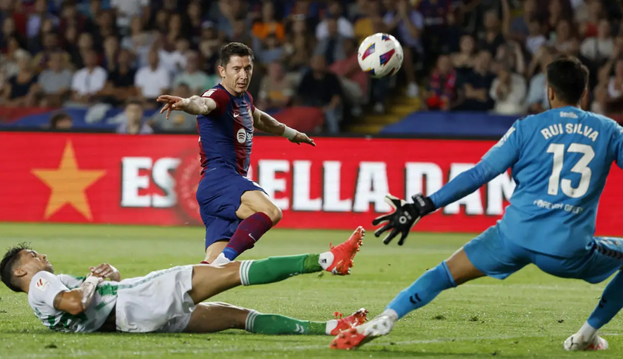 Pemain Barcelona, Robert Lewandowski, berusaha mencetak gol ke gawang Real Betis pada laga Liga Spanyol di Estadi Olimpic Lluis Companys, Minggu (17/9/2023). Barca menang dengan skor 5-0. (AP Photo/Joan Monfort)