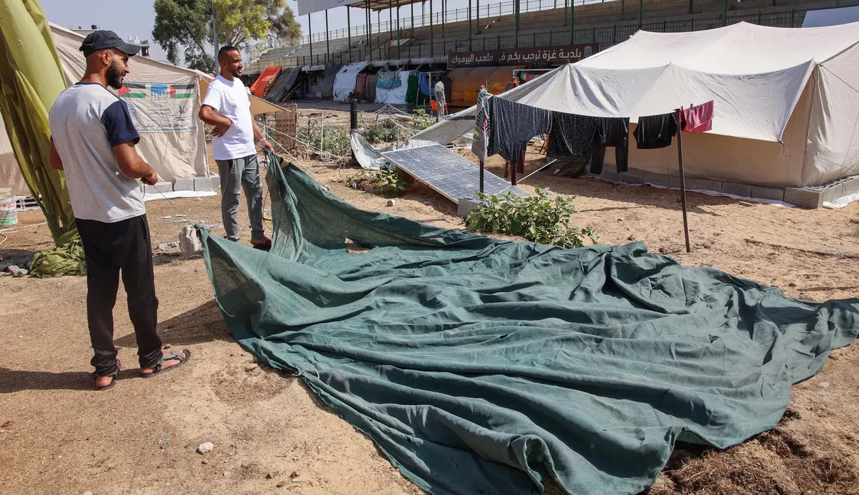 Pengungsi Palestina yang terlantar di Gaza utara membangun lokasi perlindungan di dalam stadion Yarmouk, salah satu arena sepak bola terbesar di wilayah tersebut. (Omar AL-QATTAA/AFP)