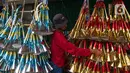 Pedagang menata terompet buatannya untuk dijual di kawasan Glodok, Jakarta, Selasa (26/12/2023). (Liputan6.com/Faizal Fanani)