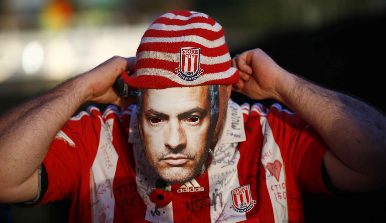 Suporter Stoke City menggunakan topeng pelatih Chelsea Jose Mourinho pada laga Liga Premier Inggris di Stadion Britania, Minggu (8/11/2015) dini hari WIB. Mourinho dilarang mendampingi timnya oleh Football Association ( FA ). (Reuters/Darren Staples)