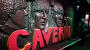 Seorang pria berjalan melewati patung wajah personel The Beatles  di Liverpool, Inggris, (16/8). Kota Liverpool  tiap tahunnya menadapat 105 juta dollar dari para penggemar The beatles dari seluruh dunia yang hadir ke kota ini. (REUTERS/Phil Noble)