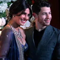 Pasangan Priyanka Chopra dan Jonas berpose untuk resepsi kedua pernikahan mereka di Mumbai, Rabu (19/12). Resepsi ketiga Priyanka Chopra dan Nick Jonas akan diadakan Kamis (20/12) malam dengan mengundang rekan selebritis Bollywood. (AP/Rajanish Kakade)