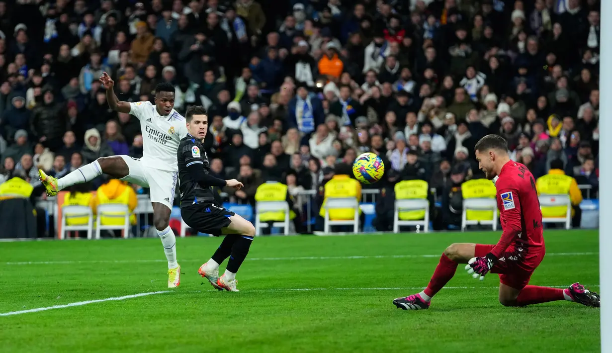 Pemain Real Madrid Vinicius Junior (kiri) menendang bola ke gawang Real Sociedad yang dijaga kiper Igor Zubeldia (tengah) pada pertandingan sepak bola Liga Spanyol di Stadion Santiago Bernabeu, Madrid, 29 Januari 2023. Pertandingan berakhir imbang 0-0. (AP Photo/Manu Fernandez)