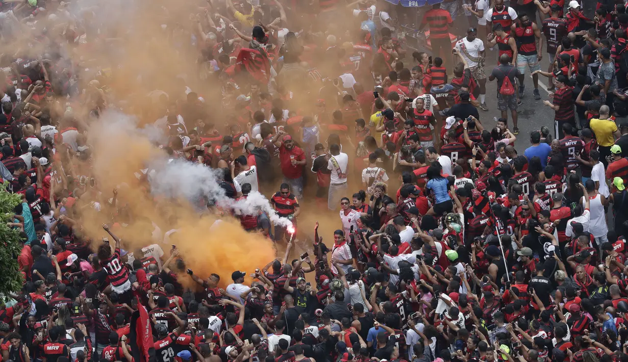 Suporter Flamengo bersorak saat menunggu kedatangan tim kesayangannya di Rio de Janeiro, Brasil (24/11/2019). Flamengo berhasil mengalahkan River Plate 2-1 pada final Copa Libertadores di Lima untuk memenangkan Gelar keduanya. (AP Photo/Silvia Izquierdo)